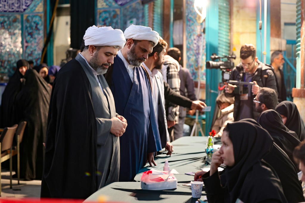 إيرانيون يسجلون قبل الإدلاء بأصواتهم في مركز اقتراع خلال انتخابات مجلس الشورى ومجلس خبراء القيادة في طهران في 1 آذار/مارس 2024 (أ ف ب)   