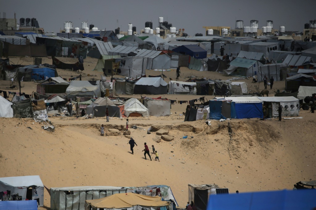 فلسطينيون يسيرون في مخيم للنازحين في رفح في أقصى جنوب قطاع غزة قرب الحدود مع مصر في 28 نيسان أبريل 2024 (ا ف ب)