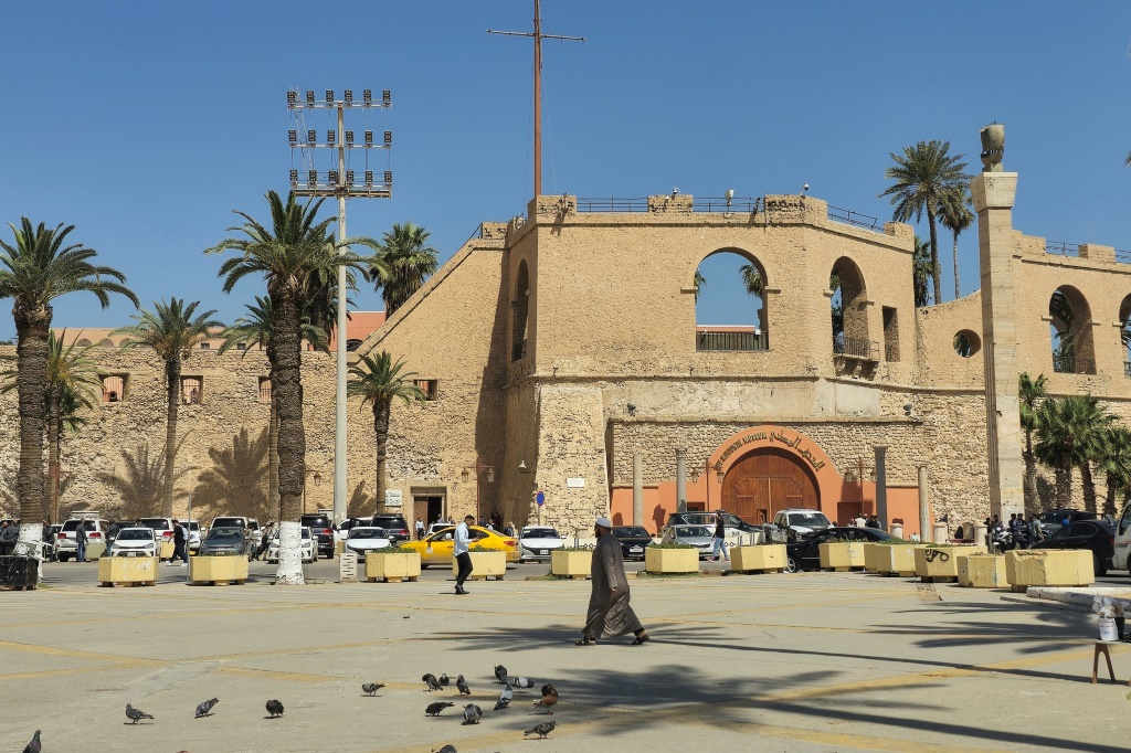 أشخاص يسيرون أمام متحف القلعة الحمراء الوطني المعروف أيضًا باسم السرايا الحمراء في طرابلس بليبيا في 12 أيار/مايو 2024 (ا ف ب)