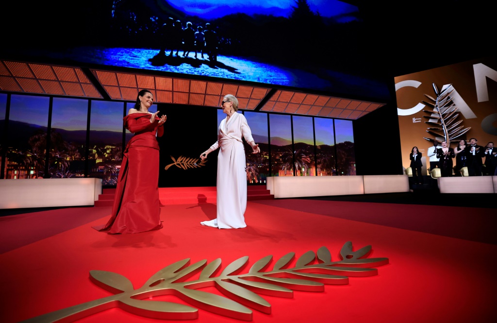 الممثلة الأميركية ميريل ستريب (إلى اليمين) قبل تسلّمها السعفة الذهبية الفخرية من الممثلة الفرنسية جولييت بينوش خلال افتتاح الدور السابعة والسبعين لمهرجان السينمائي في 14 ايار/مايو 2024 (ا ف ب)