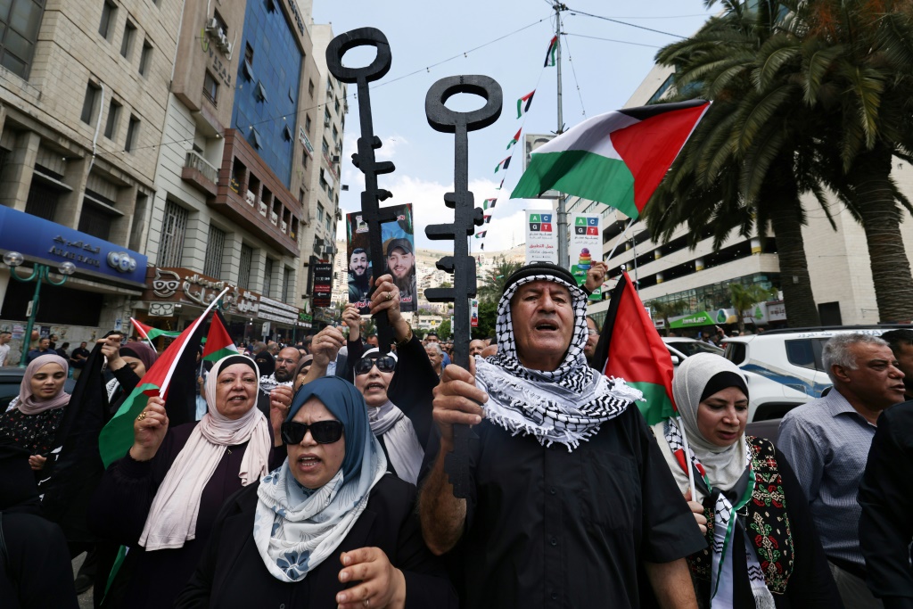 متظاهرون فلسطينيون يحملون مفاتيح رمزيا خلال مسيرة في مدينة نابلس بشمال الضفة الغربية في 15 أيار/مايو 2024 في ذكرى النكبة. (أ ف ب)   