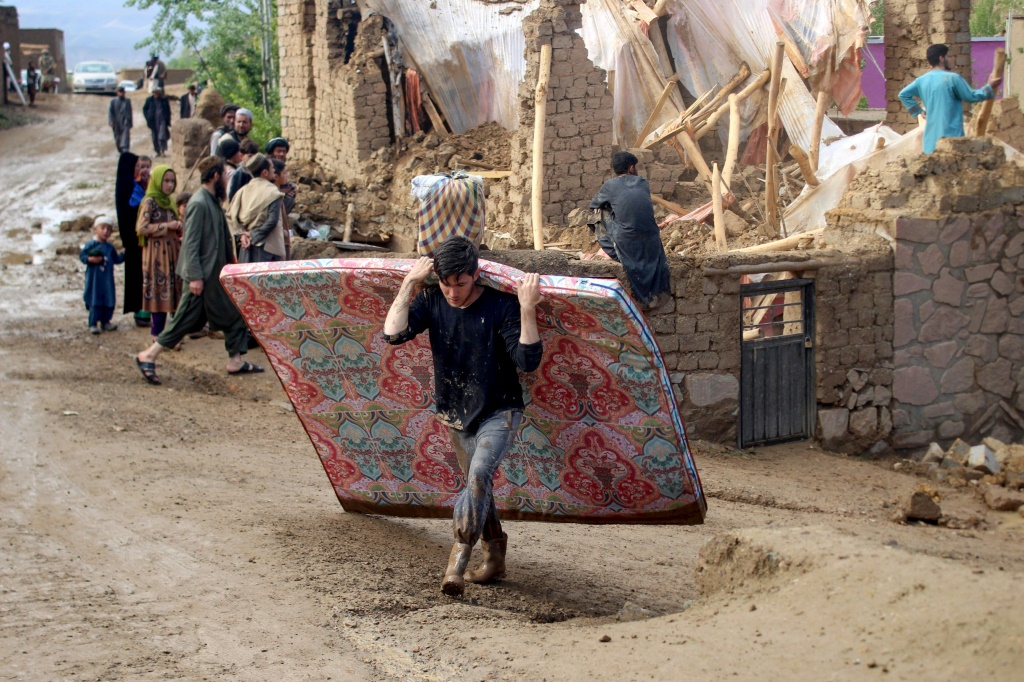 أفغان يجمعون حاجياتهم بعد تضرر مساكنهم جراء الفيضانات في ولاية غور في 18 أيار/مايو 2024 (أ ف ب)   