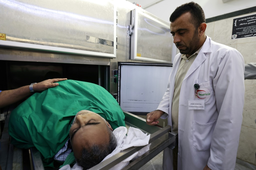 طبيب فلسطيني يقف إلى جانب جثمان أخصائي الجراحة العامة أسيد جبارين الذي قتل خلال عملية عسكرية إسرائيلية في مدينة جنين في شمال الضفة الغربية المحتلة في 21 أيار/مايو 2024 (ا ف ب)