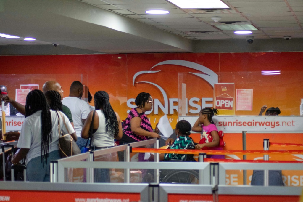 يصطف الركاب عند مكتب شركة Sunrise Airways في مطار توسان لوفرتور الدولي في هايتي في بورت أو برنس في 20 مايو 2024، وهو اليوم الأول للرحلات التجارية منذ إغلاق المطار في مارس بسبب عنف العصابات. (أ ف ب)   