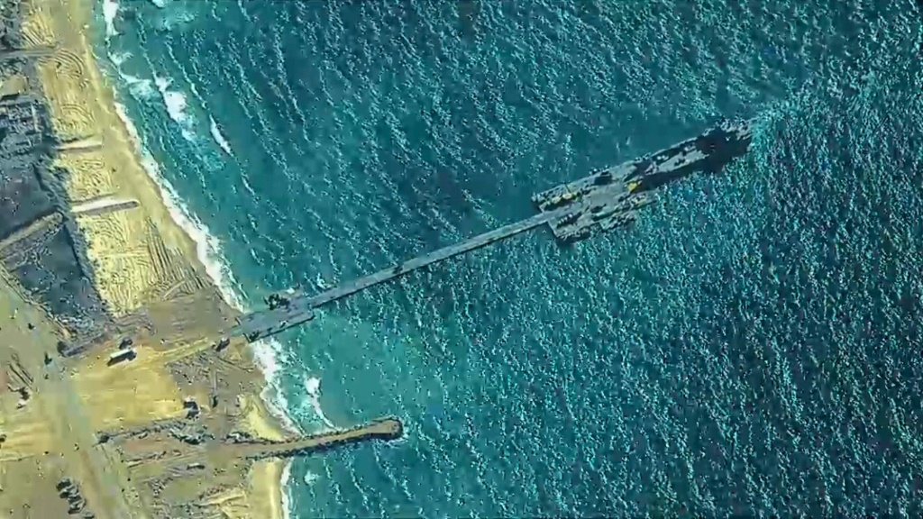 يتم تفريغ المساعدات التي يتم شحنها من قبرص إلى غزة في هذا الرصيف المؤقت الذي بنته الولايات المتحدة والراسي على الشاطئ (أ ف ب)   