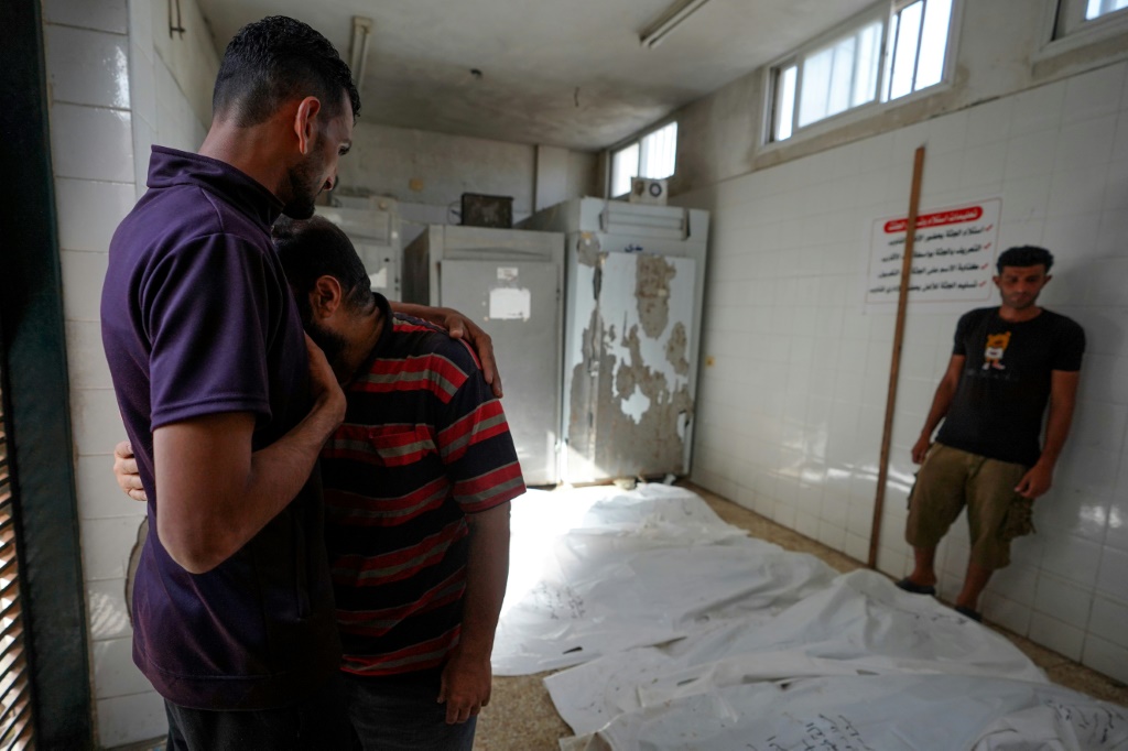 فلسطيني يبكي بعد التعرف على أحد أقاربه في مستشفى شهداء الأقصى في دير البلح في أعقاب القصف الإسرائيلي في وقت مبكر من يوم 22 أيار/مايو 2024 على بلدة الزوايدة القريبة في وسط قطاع غزة، وسط استمرار المعارك بين إسرائيل وحماس (أ ف ب)   