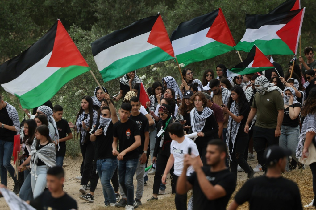    متظاهرون عرب إسرائيليون يلوحون بالأعلام الفلسطينية في وقت سابق من هذا الشهر أثناء إحياء ذكرى النزوح الجماعي الذي رافق إنشاء دولة إسرائيل في عام 1948 (أ ف ب)   