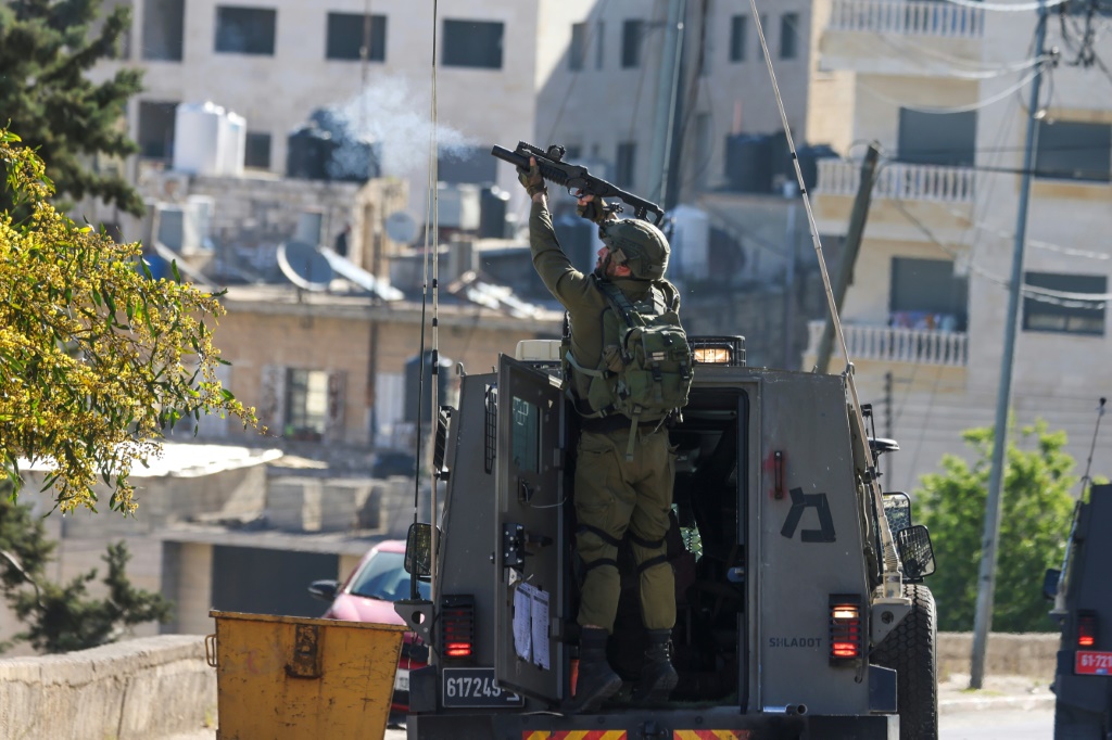 جندي إسرائيلي يطلق النار خلال صدامات مع فلسطينيين تزامنت مع مداهمة الجيش الإسرائيلي لمدينة نابلس شمال الضفة الغربية المحتلة في الثالث من نيسان/أبريل 2023 (ا ف ب)
