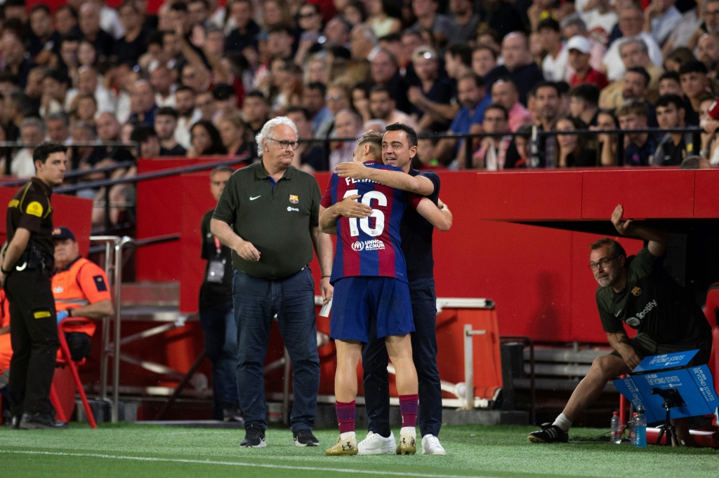 لاعب وسط برشلونة فيرمين لوبيس يحتفل بتسجيله هدفا مع المدرب المُقال تشافي هيرنانديس (ا ف ب)