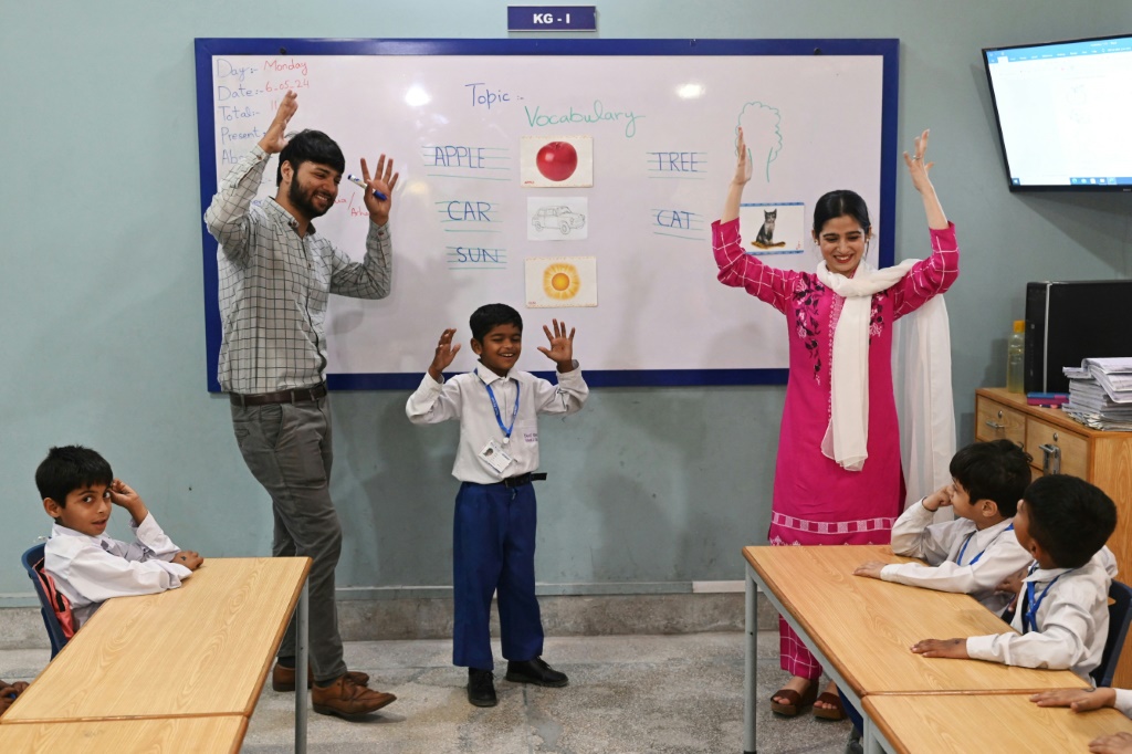 يقود المعلمون صفًا من الطلاب ضعاف السمع في مدرسة في لاهور تديرها مؤسسة Deaf Reach الخيرية، وهي منظمة غير ربحية تعمل على تمكين الأطفال والشباب الصم المحرومين (ا ف ب)