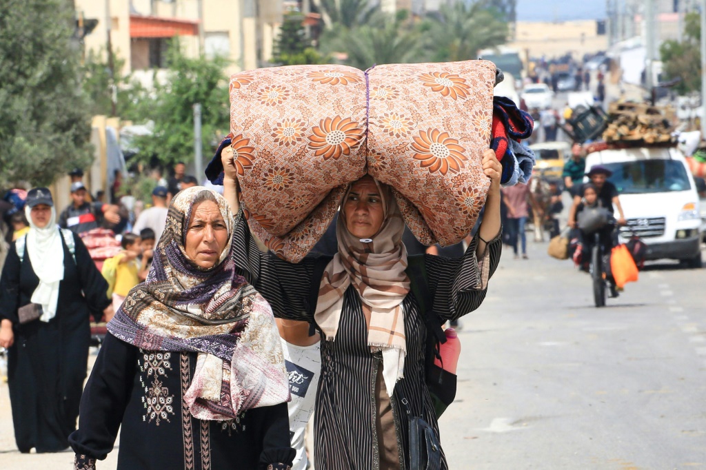 فلسطينيون يفرون من منطقة تل السلطان في رفح مع أمتعتهم (أ ف ب)   