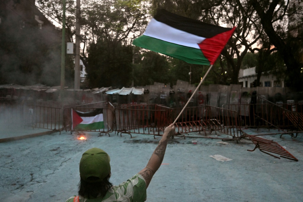 امرأة تلوح بعلم فلسطيني خلال تظاهرة أمام السفارة الإسرائيلية في مكسيكو، في 28 أيار/مايو 2024 (ا ف ب)