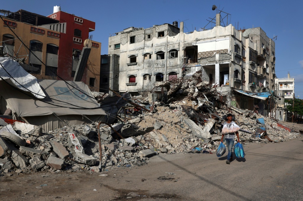 فلسطيني يسير بجوار مبنى مدمر في رفح جنوب قطاع غزة في 26 من ايار/مايو 2024 (ا ف ب)
