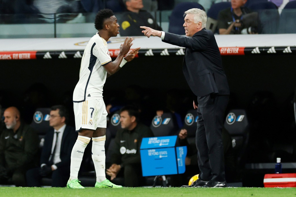 البرازيلي فينيسيوس جونيور يتحدث مع مدربه الإيطالي في ريال مدريد الإسباني كارلو أنشيلوتي خلال مواجهة الغريم برشلونة ضمن الدوري الإسباني لكرة القدم على ملعب سانتياغو برنابيو. مدريد، 21 نيسان/أبريل 2024 (ا ف ب)