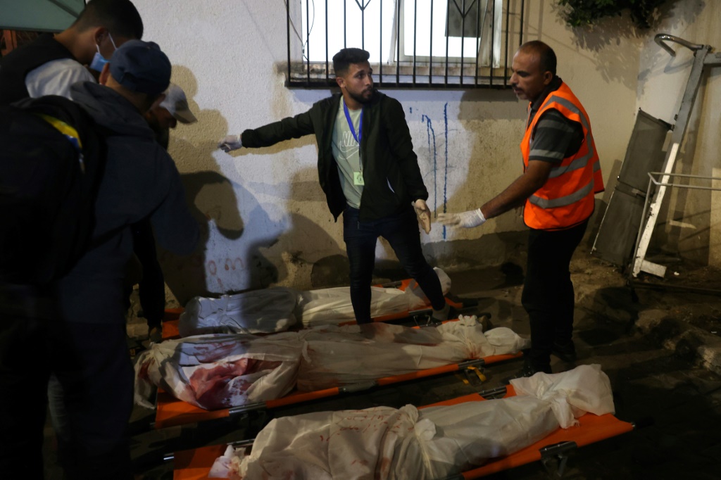 مسعفون يقومون بتجهيز جثث سكان غزة الذين قتلوا في غارة إسرائيلية على مخيم للنازحين الفلسطينيين في رفح، 26 مايو، 2024. (ا ف ب)