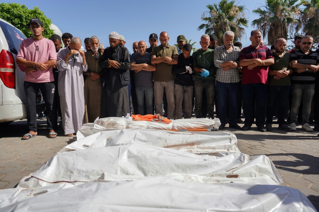 فلسطينيون يصلون على شهداء القصف الإسرائيلي، خارج مستشفى في دير البلح، 7 يونيو، 2024 (ا ف ب)