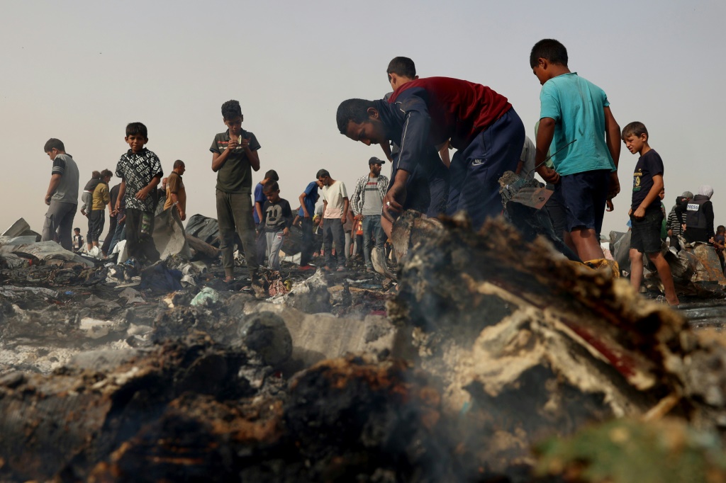 فلسطينيون يعاينون الأضرار في مخيم النازحين الذي قصفه الجيش الإسرائيلي في رفح بجنوب قطاع غزة في 27 أيار/مايو 2024 (ا ف ب)