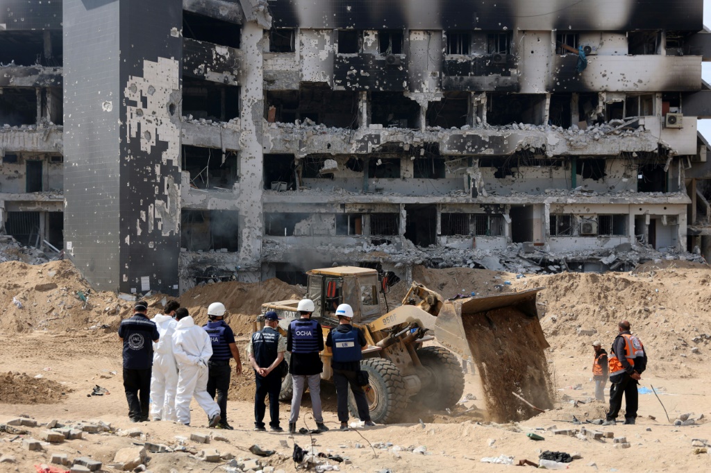 فريق من الأمم المتحدة يتفقد الأضرار التي لحقت بمستشفى الشفاء في غزة حيث عمل بارش خلال زيارة تفقدية (أ ف ب)