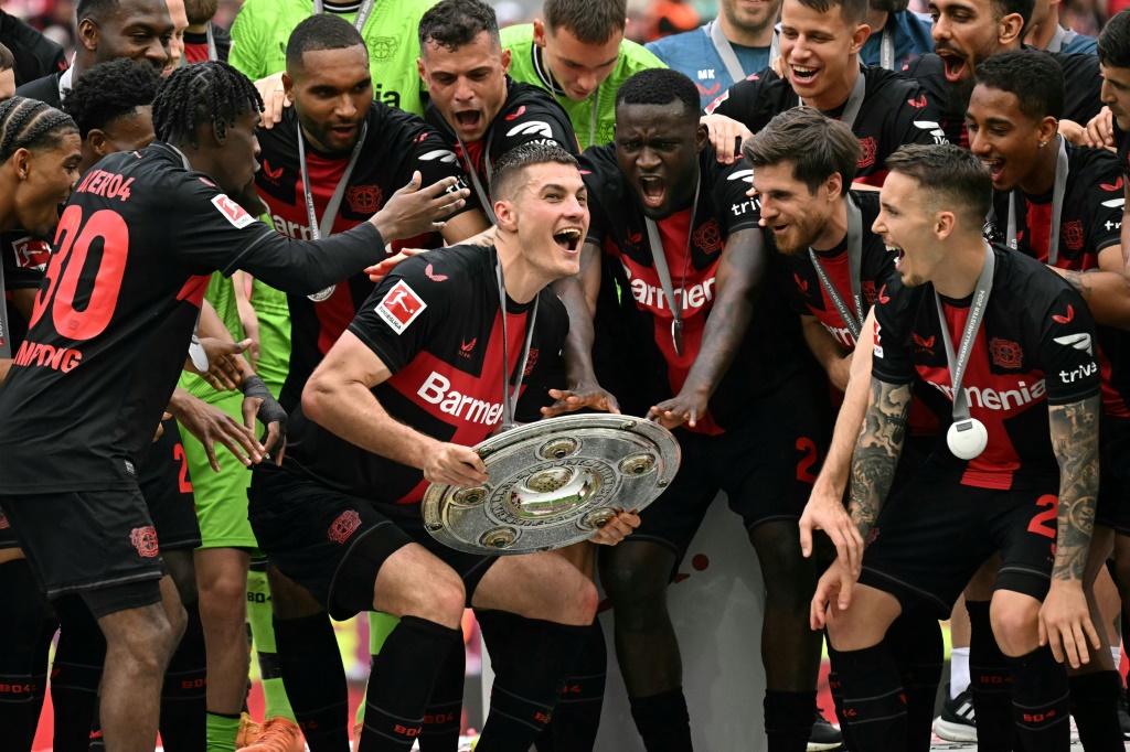 التشيكي باتريك شيك مهاجم باير ليفركوزن الألماني يحتفل مع زملائه بالتتويج بلقب الدوري للمرة الأولى في تاريخ النادي، بعد انتهاء المباراة أمام أوغسبورغ في المرحلة الأخيرة. ليفركوزن، غربيّ ألمانيا، في 18 أيار/مايو 2024 (ا ف ب)