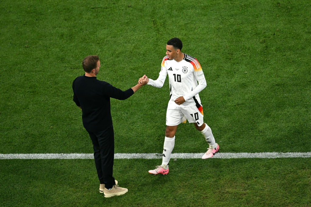 مدرب ألمانيا يوليان ناغلسمان يُهنّئ جمال موسيالا بعد استبداله في مباراة الفوز على اسكلتندا 5-1 في افتتاح كأس أوروبا 2024 لكرة القدم. 14 حزيران/يونيو، ميونيخ (ا ف ب)