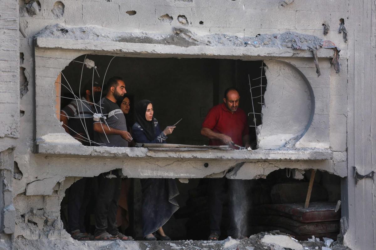 اسرة فلسطينية تتفقد بيتها المهدم جراء القصف الاسرائيلي (أ ف ب)