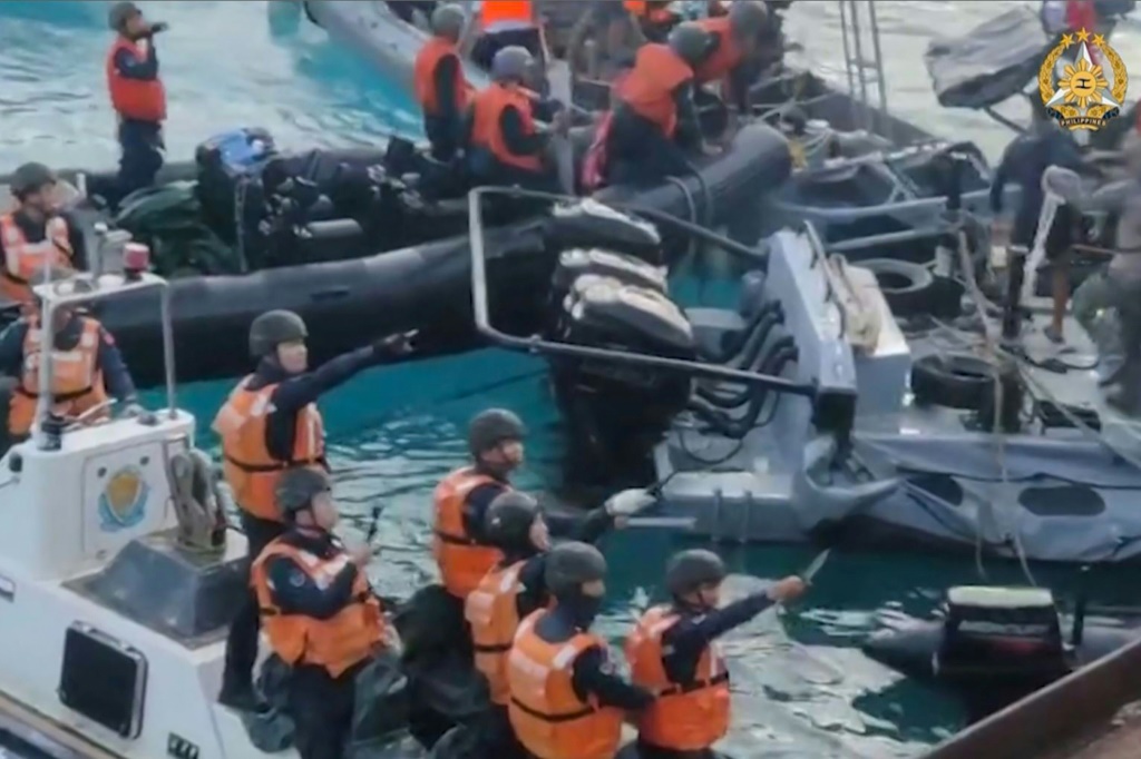    مشهد يُظهر أفراد من خفر السواحل الصينيين وهم يحملون أسلحة بيضاء أثناء حادث قبالة جزيرة مرجانية في بحر الصين الجنوبيتم التقاطه في 17 حزيران/يونيو 2024  (أ ف ب)   