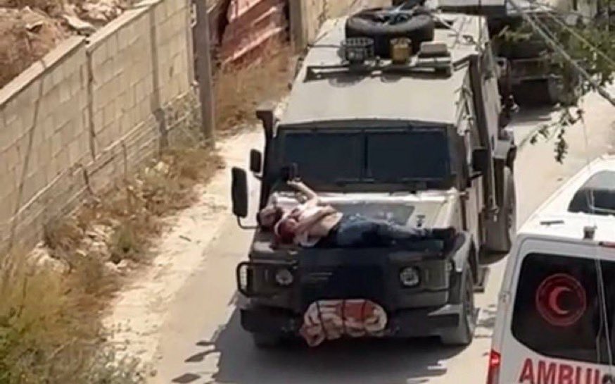 تقييد قوات الجيش الإسرائيلي لمواطن فلسطيني مصاب بمقدمة مركبة عسكرية (مواقع التواصل)
