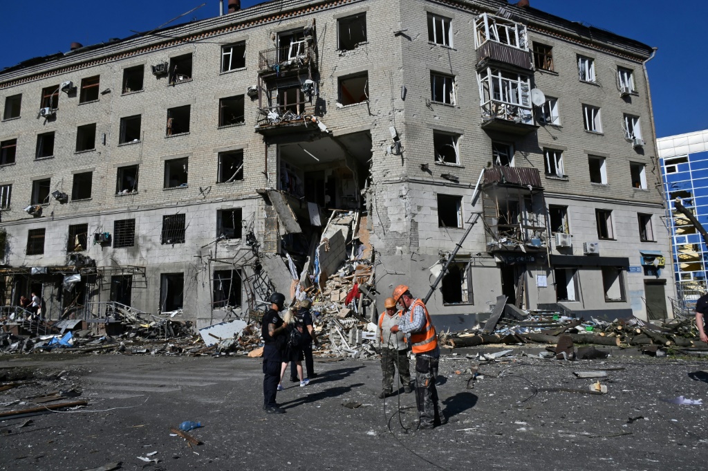 مسعفون وشرطيون امام مبنى مدمر اثر قصف جوي في وسط مدينة خاركيف الاوكرانية في 22 حزيران/يونيو 2024 (أ ف ب)   