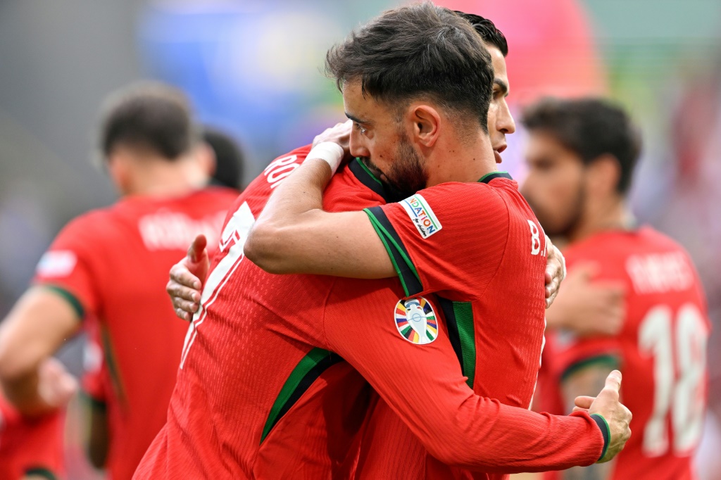  برونو فرنانديش (يمين) يُعانق كريستيانو رونالدو بعد الهدف الثالث لمنتخب بلادهما البرتغال أمام تركيا، في الجولة الثانية من منافسات المجموعة السادسة من كأس أوروبا 2024 لكرة القدم. دورتموند، 22 حزيران/يونيو 2024 (ا ف ب)