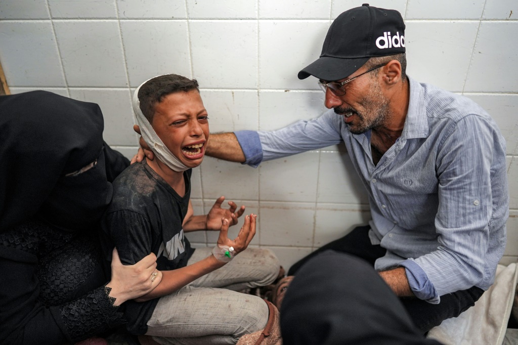 طفل مصاب ينعي فقدان والده في غارة على مخيم المغازي للاجئين وسط قطاع غزة، في مشرحة المستشفى (أ ف ب)   