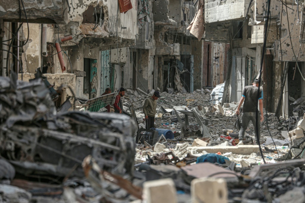 فلسطينيون يبحثون عن مقتنيات شخصية في أنقاض مبان في خان يونس في 22 نيسان/أبريل 2024 (ا ف ب)