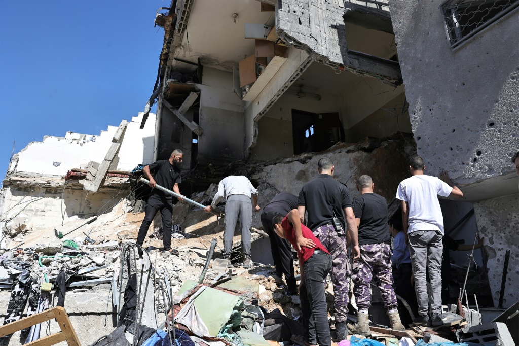    فلسطينيون يبحثون بين ركام مبنى اصيب بقصف اسرائيلي في مخيم نور شمس في الضفة الغربية المحتلة في 30 حزيران/يونيو 2024 (أ ف ب)   