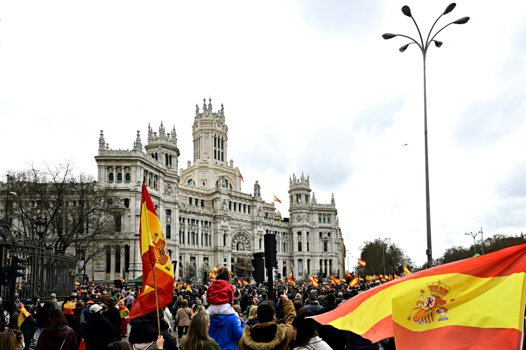 العلم الإسباني يرفرف خلال تظاهرة قرب بلدية العاصمة مدريد في 19 آذار/مارس 2022 (اف ب)