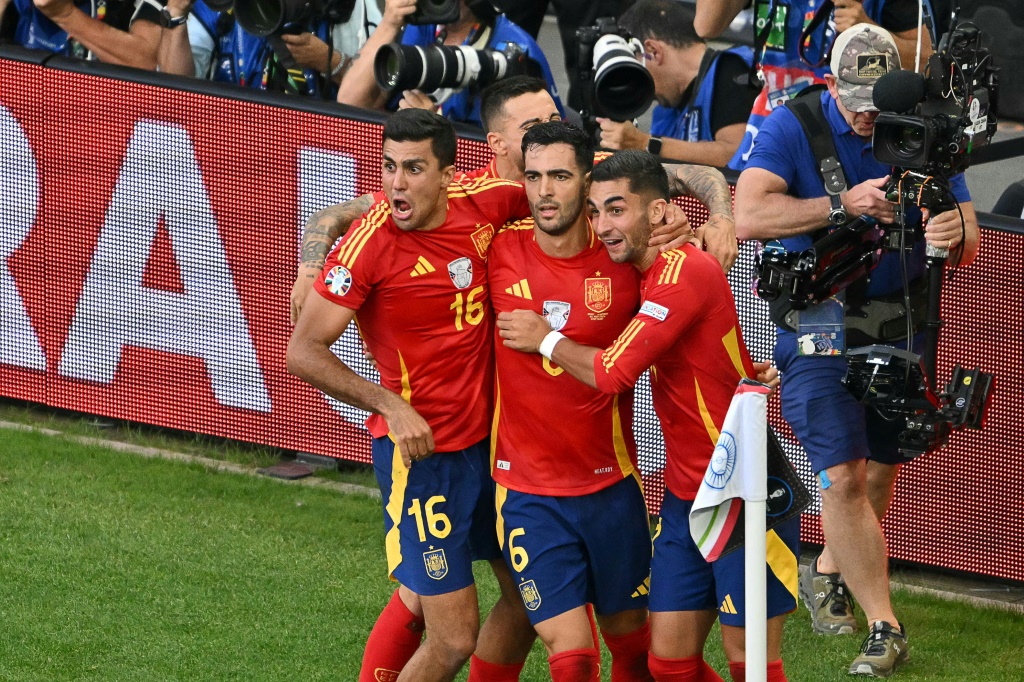 ميكيل ميرينو يحتفل مع زملائه بعد تسجيله هدف الفوز لإسبانيا على ألمانيا (2-1) في الدقيقة الاخيرة من الوقت الاضافي الثاني (ا ف ب)
