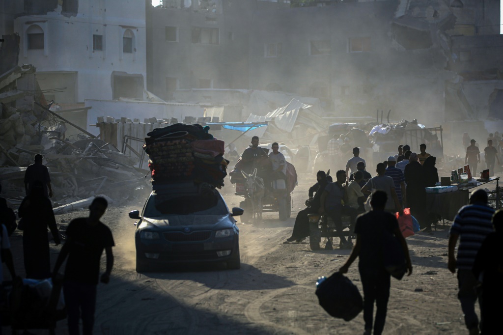 فلسطينيون يفرون بعد أن أصدر الجيش الإسرائيلي أوامر إخلاء لمناطق واسعة في جنوب غزة، بالقرب من مدينتي خان يونس ورفح (أ ف ب)