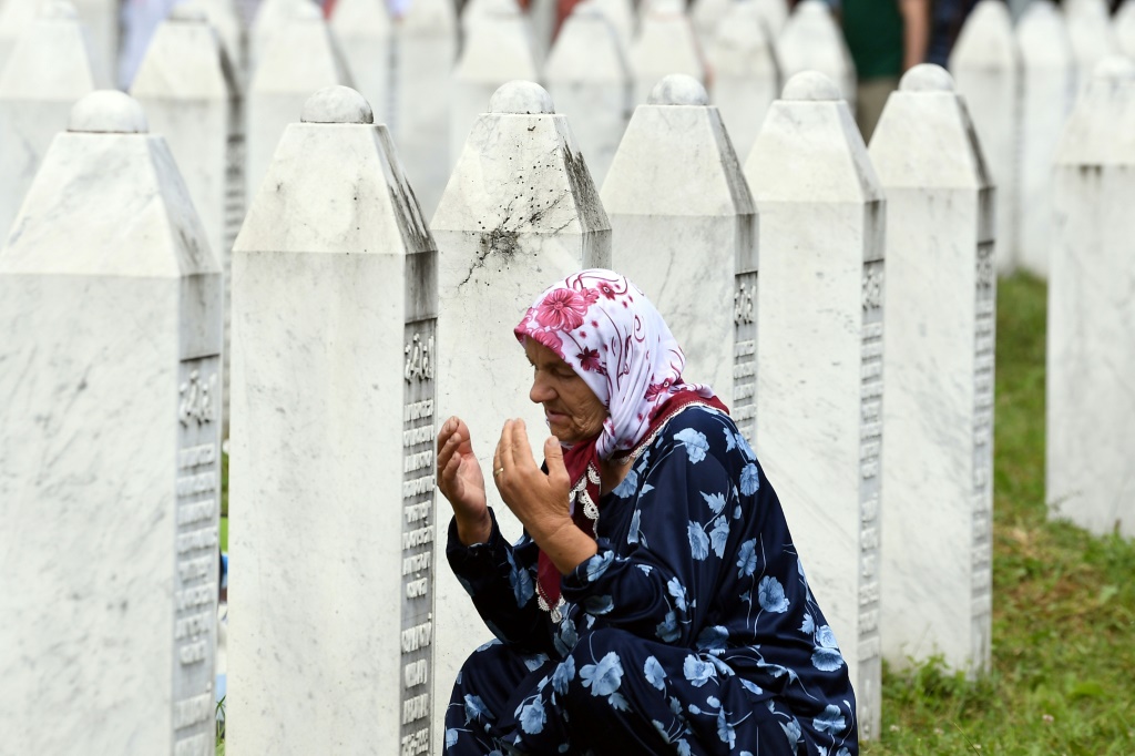 امرأة مسلمة بوسنية، إحدى الناجيات من مذبحة سربرينيتشا عام 1995، تصلي في المقبرة التذكارية في قرية بوتوكاري (أ ف ب)   