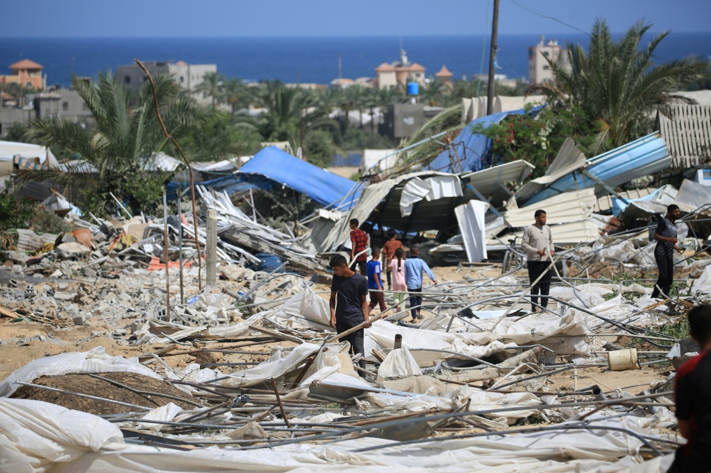 أشخاص يبحثون عن أشياء قابلة للإنقاذ بعد غارة إسرائيلية في منطقة المواصي جنوب غزة في 29 يونيو 2024 (أ ف ب)   