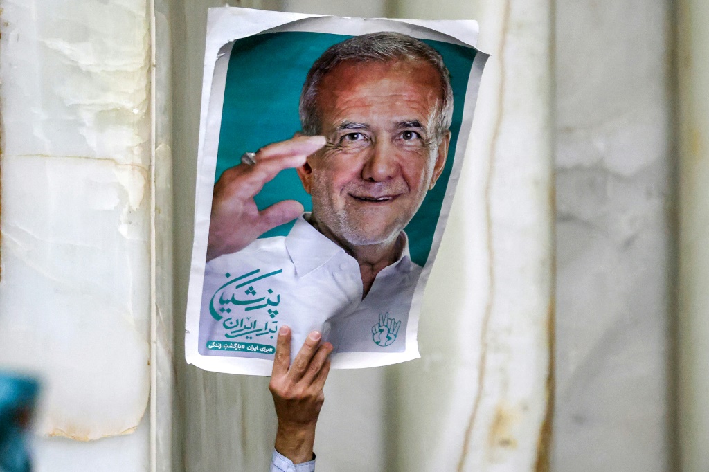    رجل يحمل صورة للرئيس الإيراني المنتخب مسعود بزشكيان في طهران في السادس من تموز/يوليو 2024 (أ ف ب)   