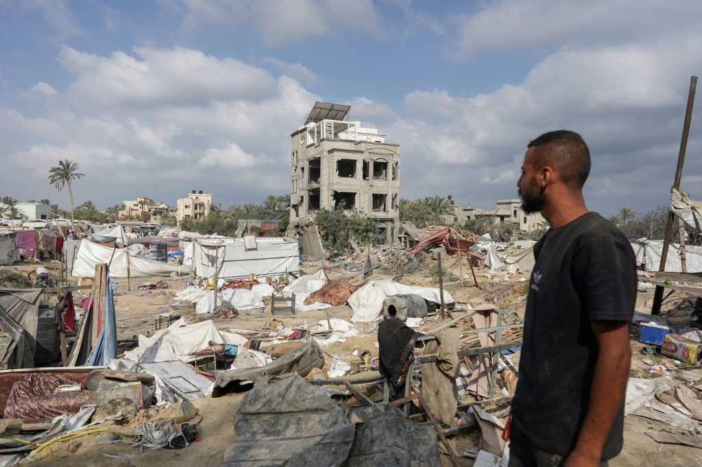 فلسطيني يتأمل ما تبقى من الخيم في مخيم المواصي للنازحين قرب خان يونس جنوب قطاع غزة في 14 تموز/يوليو 2024 غداة استهدافه بغارة إسرائيلية (أ ف ب)   