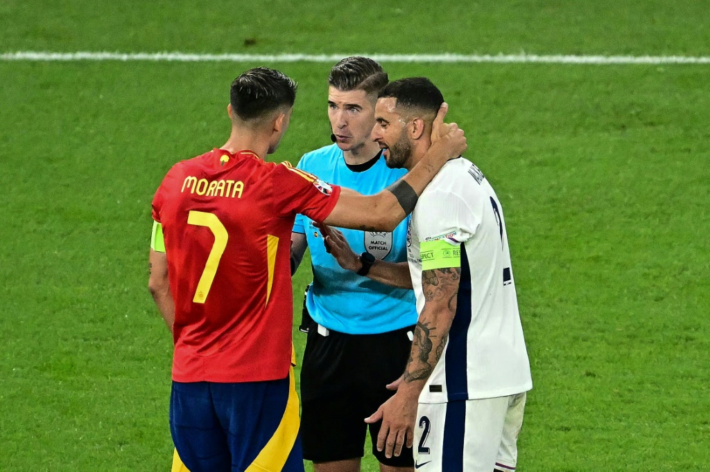 الحكم الفرنسي فرانسوا لوتوكسييه يتناقش مع قائد إسبانيا ألفارو موراتا وقائد إنكلترا كايل ووكر، في نهائي كأس أوروبا 2024 لكرة القدم. 14 تموز/يوليو (ا ف ب)