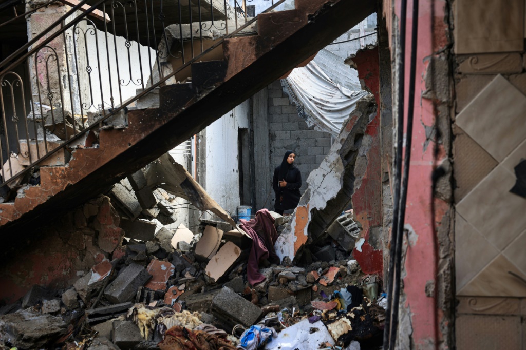   فلسطينيون يتفقدون مئذنة مسجد هدمت جراء القصف الإسرائيلي على مخيم النصيرات وسط قطاع غزة (أ ف ب)   