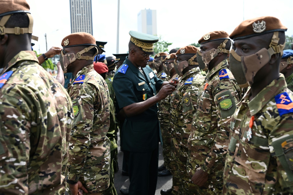 رئيس أركان القوات المسلحة في ساحل العاج العقيد لاسينا دومبيا يقلّد أوسمة لجنود ينتمون إلى بعثة الأمم المتحدة المتكاملة المتعددة الأبعاد لتحقيق الاستقرار في مالي (مينوسما) خلال مراسم احتفالية في أبيدجان في 24 كانون الثاني/يناير 2023 (أ ف ب)   