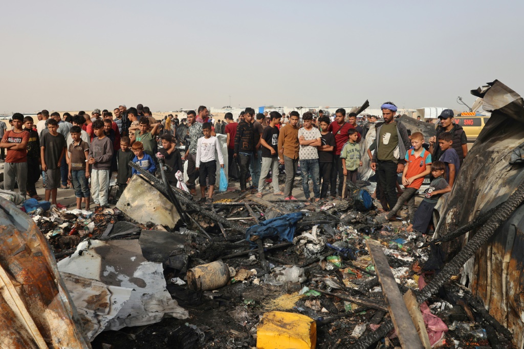 فلسطينيون تجمعوا في 27 أيار/مايو 2024 في المكان الذي كان فيه مخيم للنازحين تعرض لقصف إسرائيلي في منطقة تل سلطان في رفح (ا ف ب)