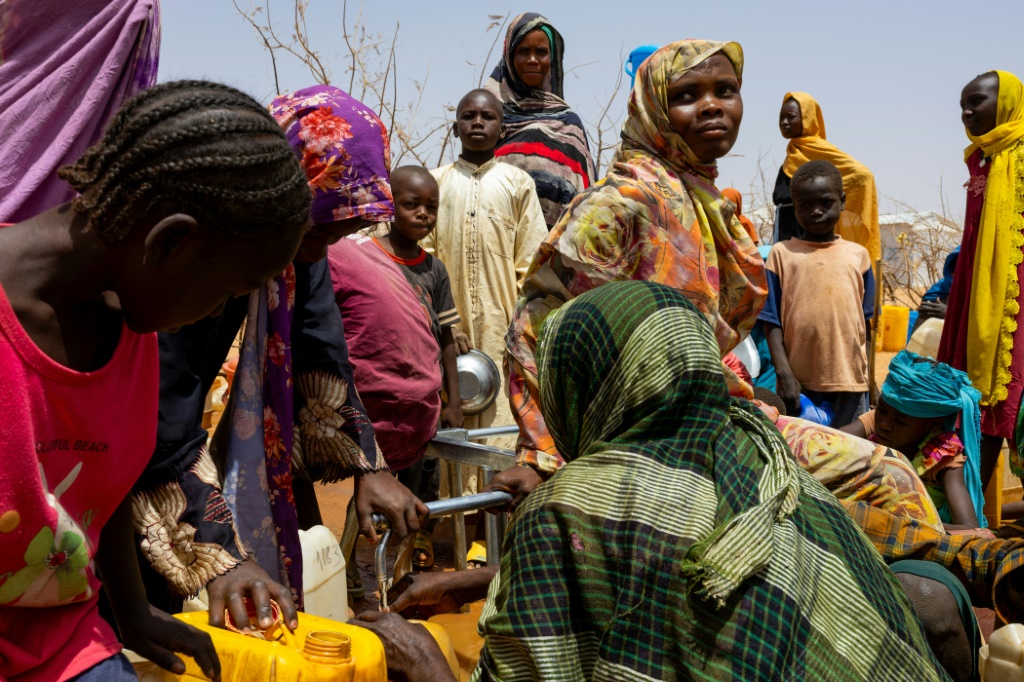 لاجئون سودانيون يتجمعون لملء المياه في مخيم فرشانا للاجئين، في 8 نيسان/أبريل 2024. تشاد تستقبل أكبر عدد من اللاجئين السودانيين، ما يقرب من مليون لاجئ (ا ف ب)   