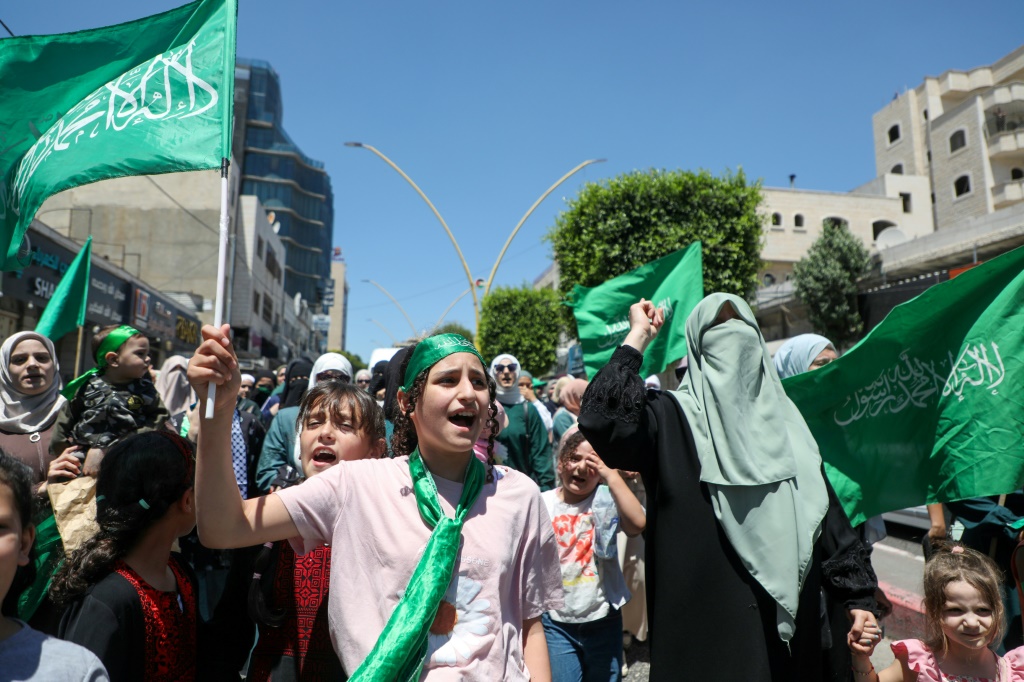 فلسطينيون يلوحون بالأعلام ويهتفون احتجاجا على اغتيال قائد حماس اسماعيل هنية في مدينة الخليل بالضفة الغربية المحتلة، في 31 تموز/يوليو 2024 (أ ف ب)   