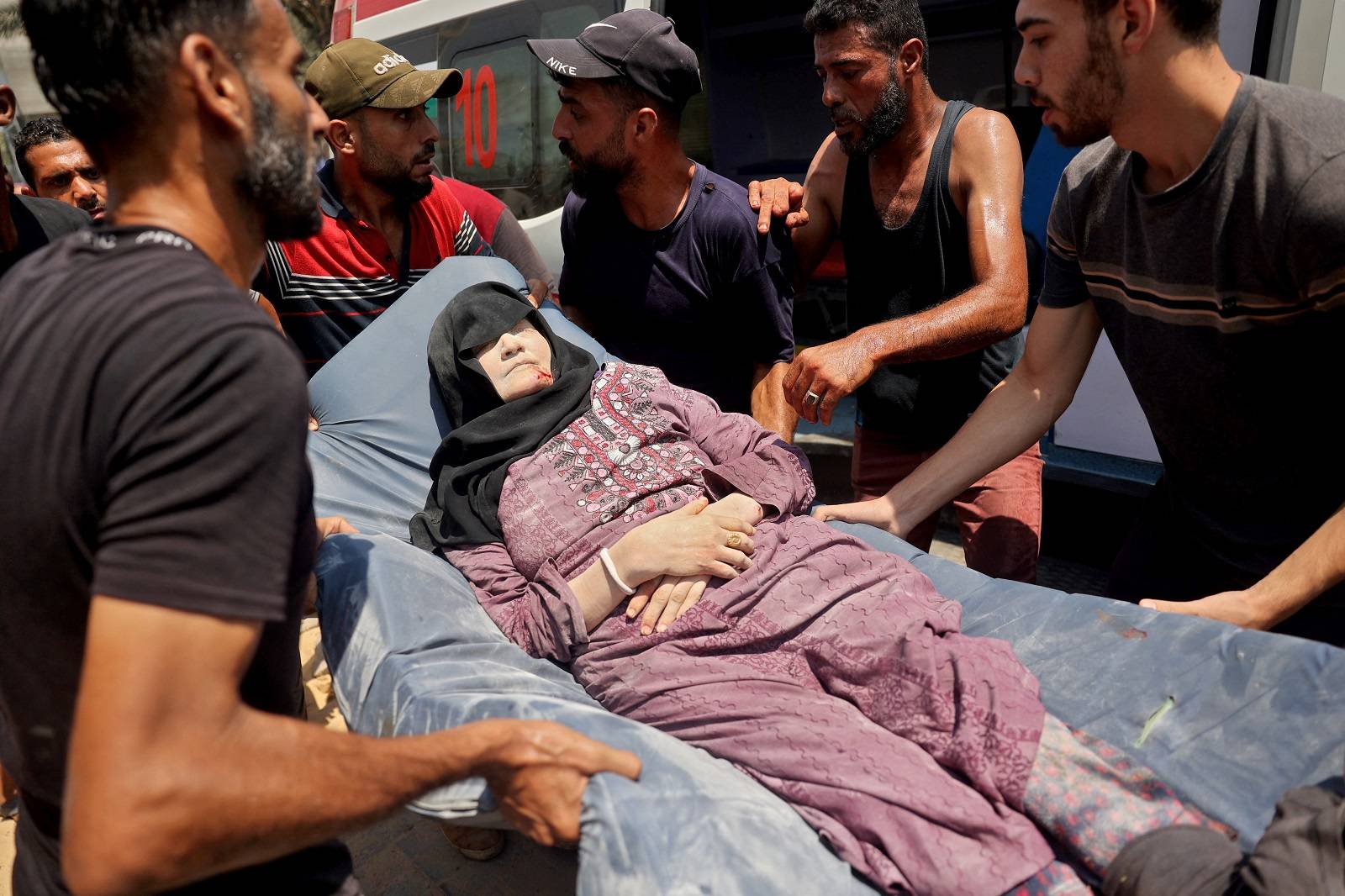 امرأة فلسطينية مصابة بعد غارة إسرائيلية على مدرسة تؤوي النازحين في دير البلح (أ.ف.ب)