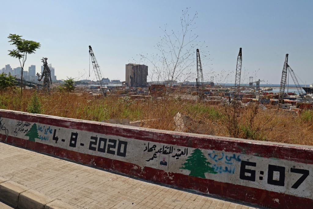 مشهد عام لاهراءات القمح في مرفأ بيروت كما بدت في 22 تموز/يوليو 2023 مع جدارية للعلم اللبناني يظهر فيها تاريخ الانفجار المروع وتوقيت حدوثه في الرابع من آب/أغسطس 2020 (أ ف ب)   