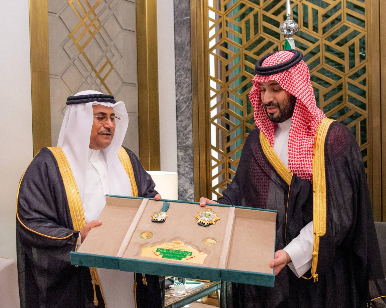 الأمير محمد بن سلمان لدى تسلمه الوسام من عادل العسومي في جدة (واس)