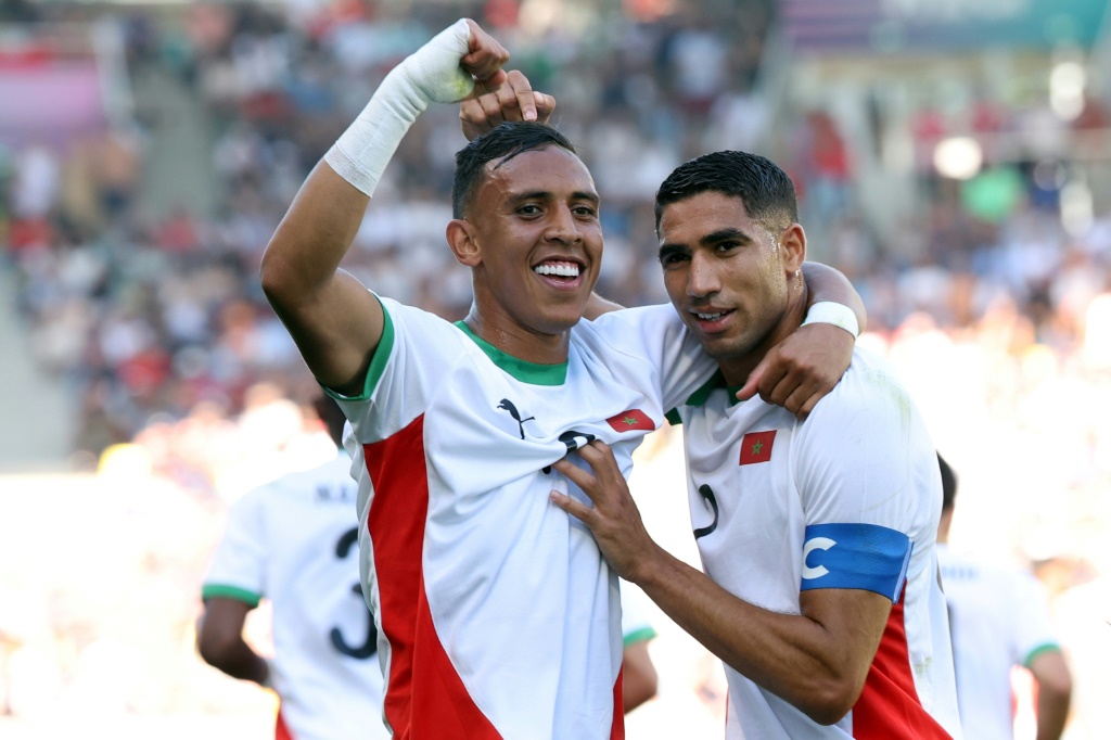 قائد المنتخب المغربي أشرف حكيمي (يمين) والهداف سفيان رحيمي يحتفلان بهز شباك مصر (6-0) في مباراة تحديد المركز الثالث في اولمبياد باريس على ملعب لا بوجوار في نانت في الثامن من آب/أغسطس 2024 (ا ف ب)