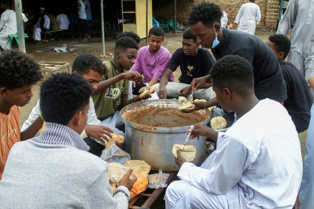 نازحون سودانيون يتناولون الطعام في احد مخيمات القضارف بشرق البلاد في 13 تموز/يوليو 2024 (أ ف ب)   